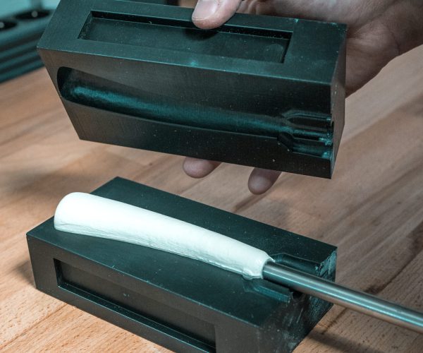 Geöffnete Form mit frisch gegossenem Eisstock-Stielgriff.